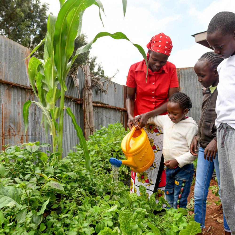 belinda with her children in their cone garden which is at the nearby offices of beacon of hope phot